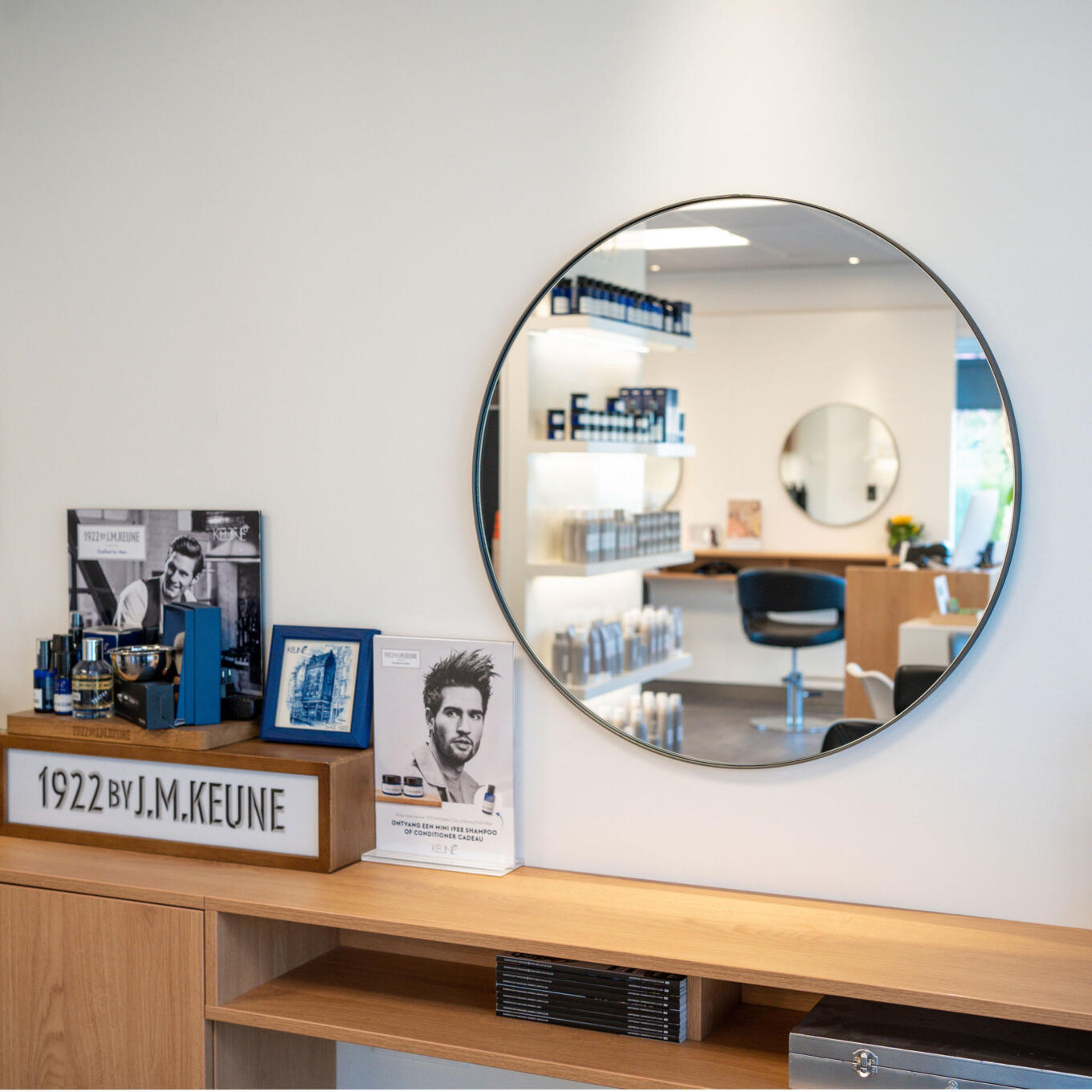 Een ronde kappersspiegel bevestigd aan de muur van een kapsalon