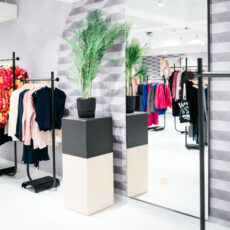 Verzilverde passpiegel tegen de wand in een kledingwinkel