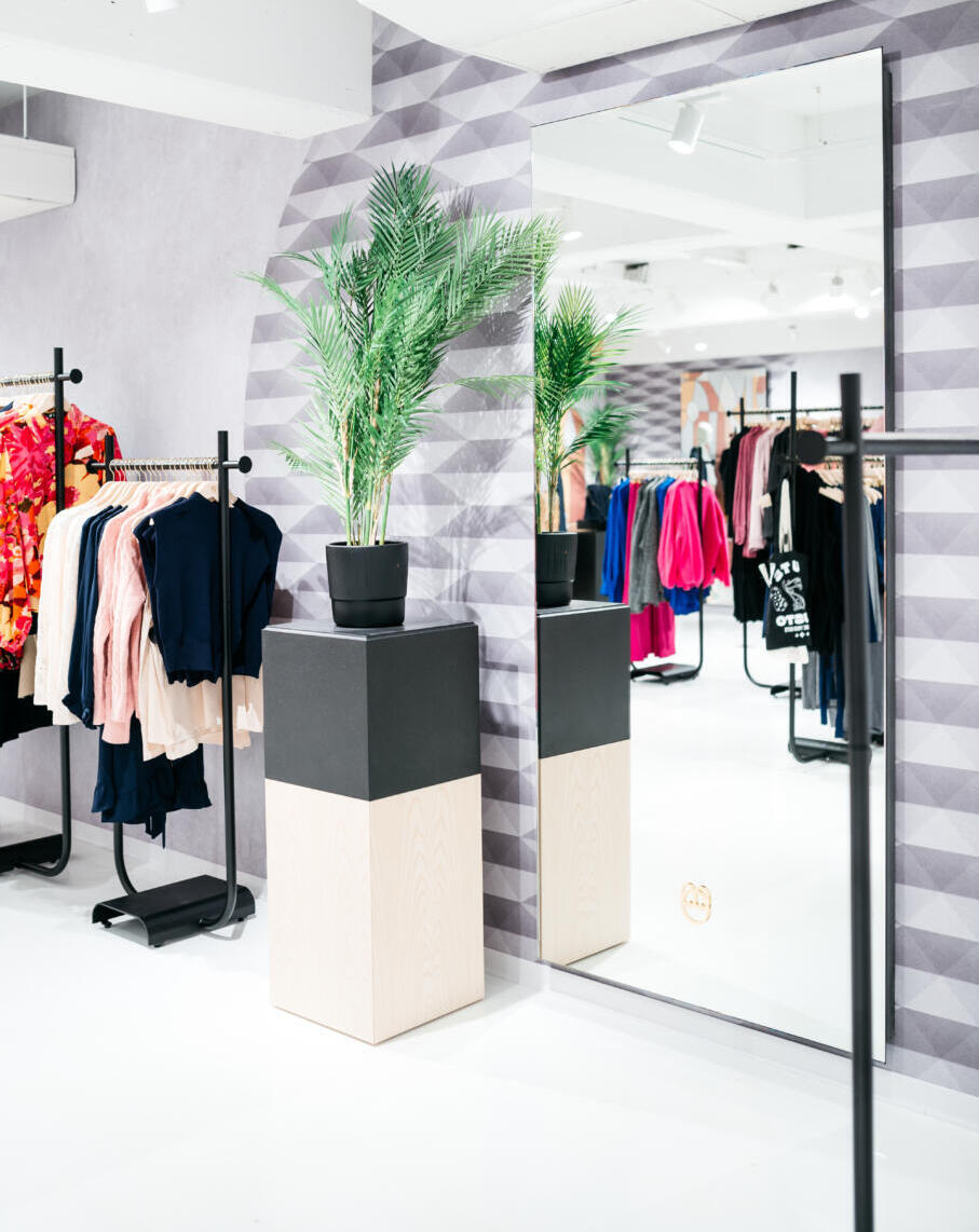 Verzilverde passpiegel tegen de wand in een kledingwinkel