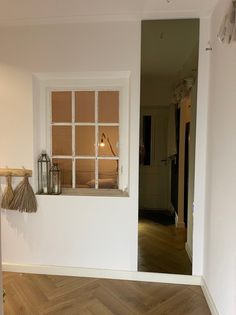 Plakspiegel aan een muur in de woonkamer