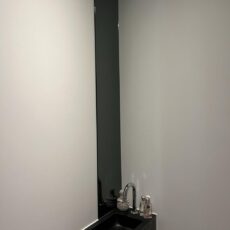 Lange smalle spiegel boven de wasbak. Vastgelijmd in de toiletruimte