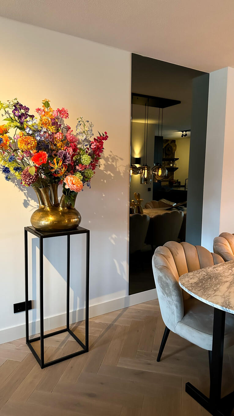 Moderne spiegel in de kleur grijs, hangend aan de muur in de woonkamer.