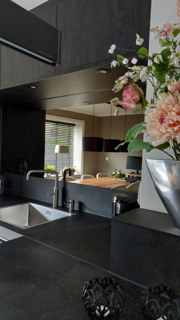 Bronzen spiegel op de wand in de keuken achter de wasbak